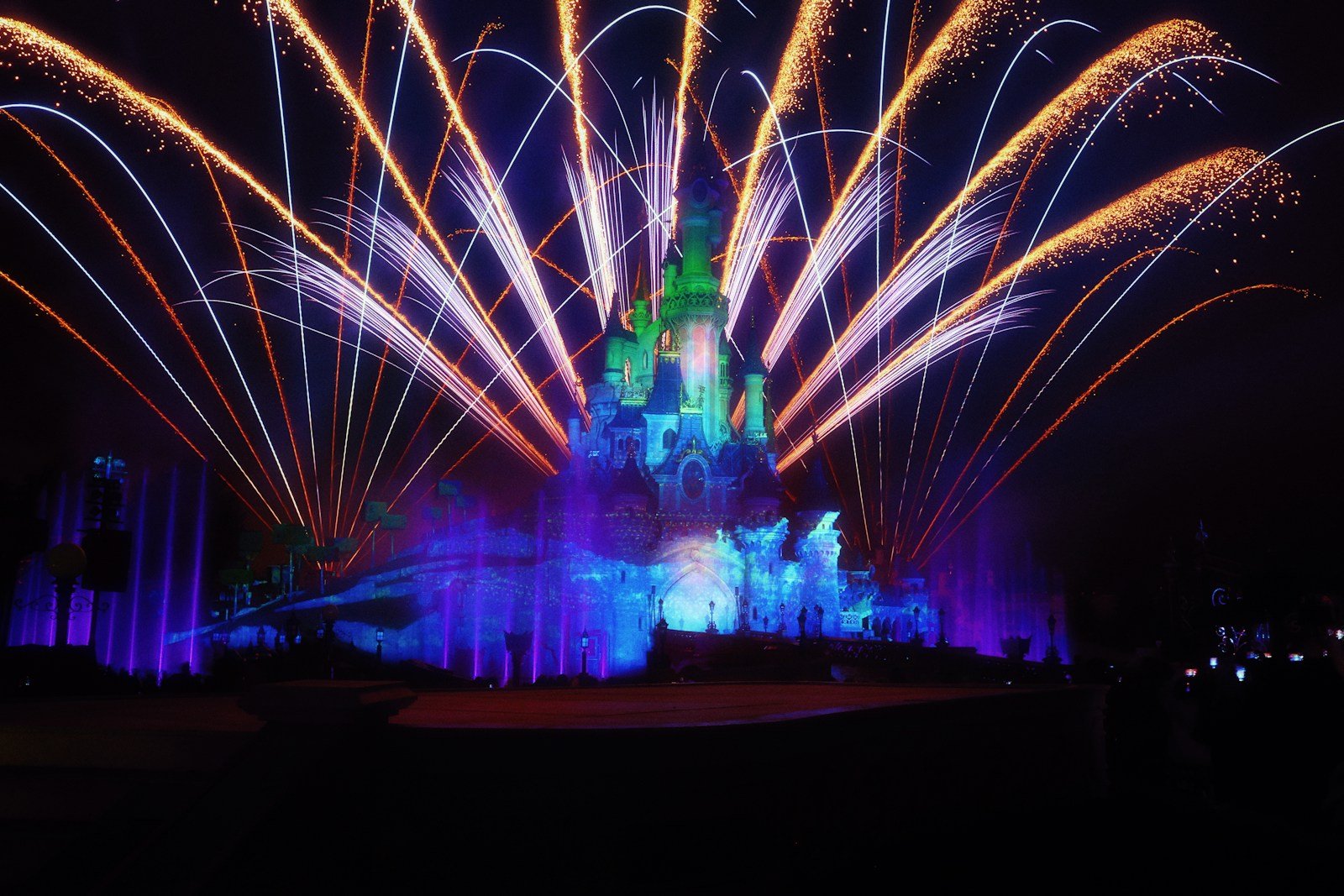A castle lit up at night with fireworks
